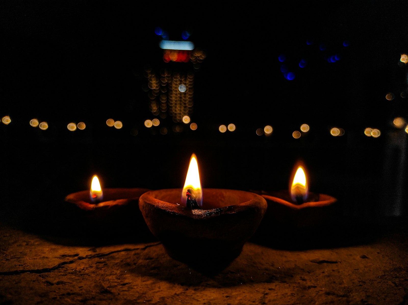 Rows of lit clay diyas glowing during a festival