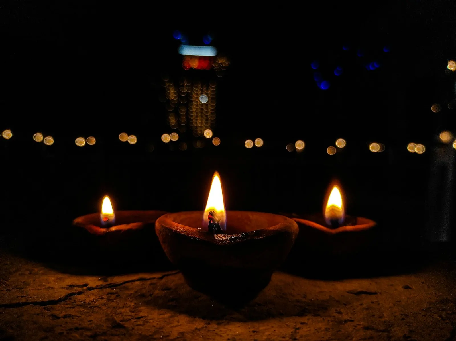Rows of lit clay diyas glowing during a festival