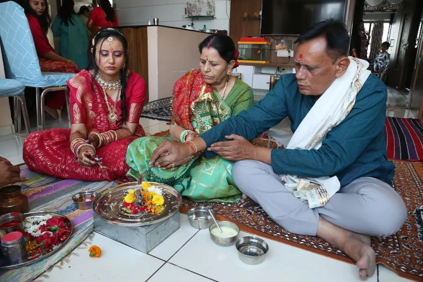 A family performing a traditional pooja together at home