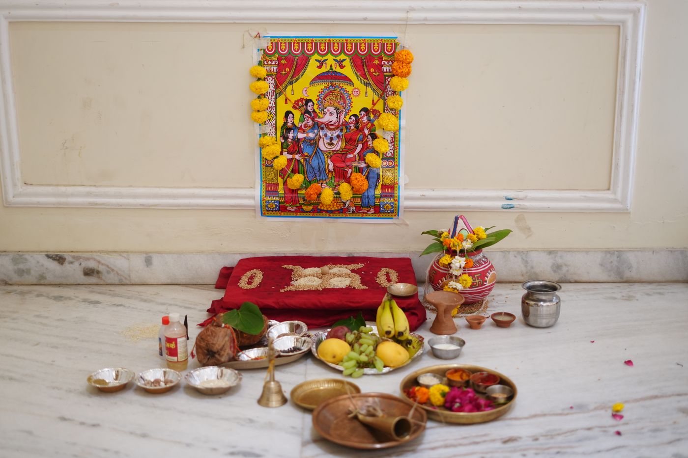 A decorated altar with a deity, flowers and offerings